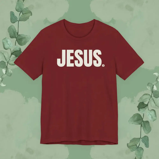 Red t-shirt with 'JESUS' printed on it against a green leafy background