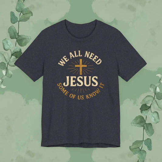Navy blue t-shirt with 'We All Need Jesus' text and cross on a green leafy background