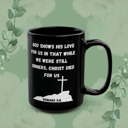 Black Christian mug with “Christ Died for Us” Romans 5:8 scripture design