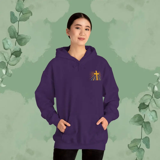 Person wearing a purple hoodie with a cross design on a green background