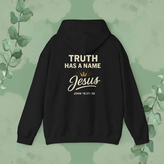 Black hoodie with 'Truth Has a Name Jesus' text on the back against a green leafy background